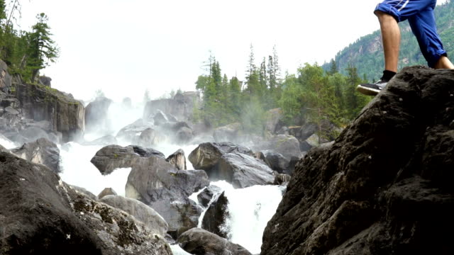 The-traveler-scrambles-along-the-cascading-waterfall.