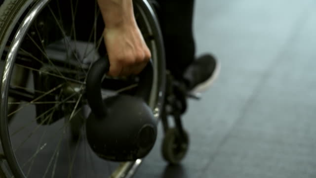 Mann-im-Rollstuhl-Zeilen-Übung-mit-der-Kettlebell
