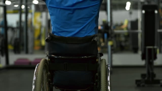 Hombre-en-silla-de-ruedas-entrenamiento-en-máquina-de-Cable-en-gimnasio