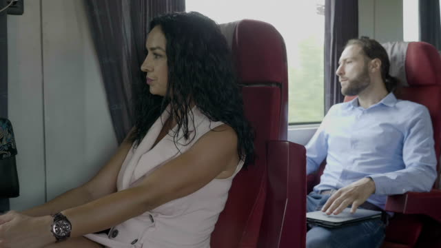 Geschäftsmann-und-elegante-Beifahrerin,-die-mit-dem-Zugbegleiter-unterwegs-ist,-indem-sie-digitales-Smartphone-während-der-Fahrt-entspannen.