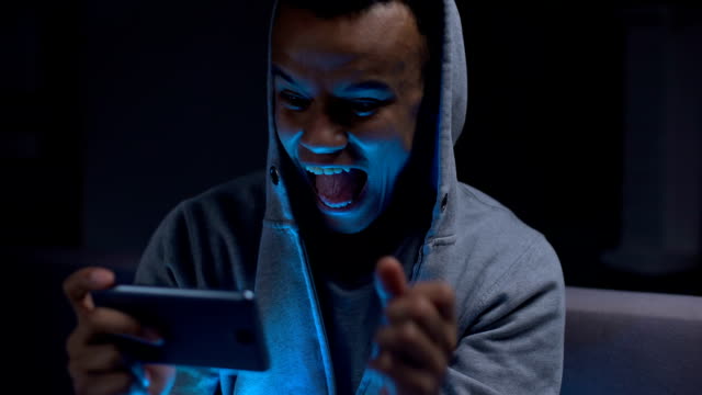 Extremely-emotional-black-guy-winning-video-game-on-smartphone,-overreacting