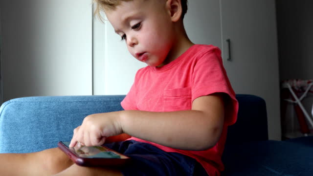 Content-kid-playing-smartphone-on-sofa