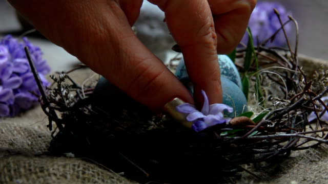 Hände-schmücken-Osternest-eine-Hyazinth-Blüte
