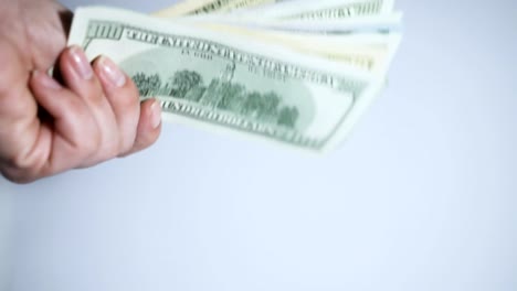 A-woman's-hand-holding-the-US-dollars-on-white-background.-Close-up