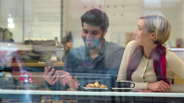 technologie.-Glückliche-Menschen-mit-Handy-Spaß-im-Café