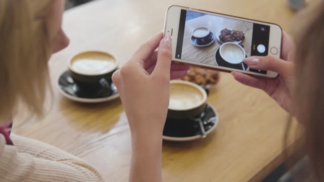 Frau-Hands-nimmt-Lebensmittel-auf-Handy-im-Cafe-Closeup