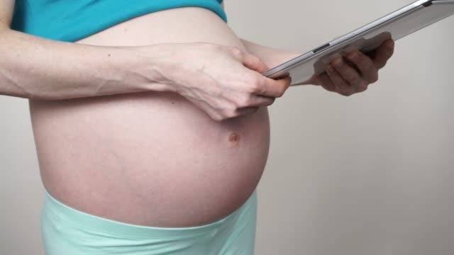 Pregnant-woman-using-digital-tablet-4K
