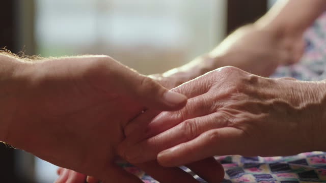 Die-junge-Frau-hilft-ihrer-Großmutter,-die-Hände-zu-nehmen.