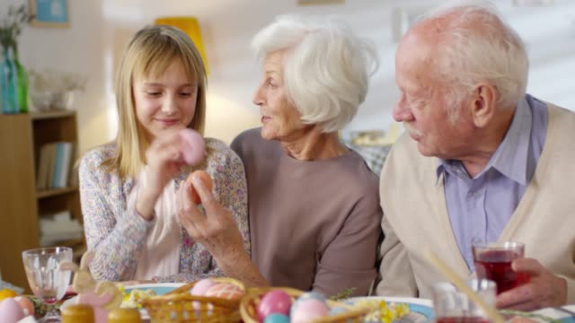Mädchen-spielen-mit-Großeltern-beim-Osteressen