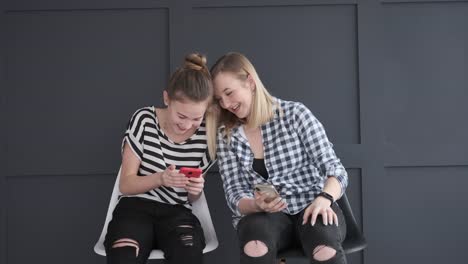 Teen-girls-discussing-while-using-social-media-app-on-mobile-phones