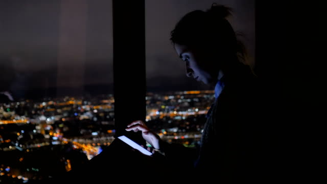 Woman-using-vertical-black-smartphone-at-night