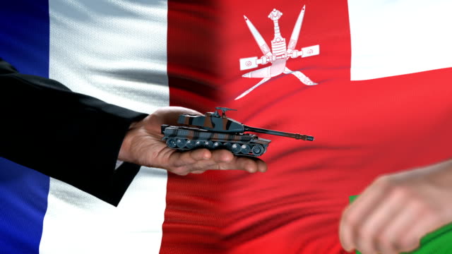 Frankreich-und-Oman-Beamte-tauschen-Tank-gegen-Geld,-Flagge-Hintergrund-Verhandlungen