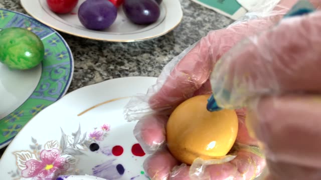 Eine-Frau-in-Handschuhen-malt-Eier