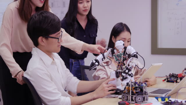 Group-of-electronics-engineer-try-to-fix-robot-at-lab.-Technology-and-innovation-concept.
