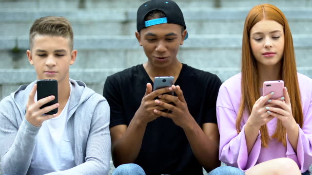 Freunde-chatten-soziale-Netzwerke-auf-Handys-im-Freien,-freudige-teen-teilen-Nachrichten