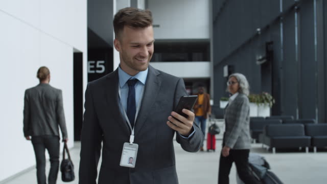 Businessman-Using-Phone-in-Airport