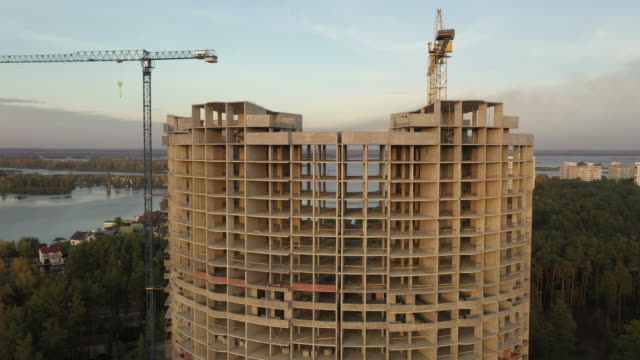 4k-Aerial-view-big-construction-cranes-and-unfinished-house