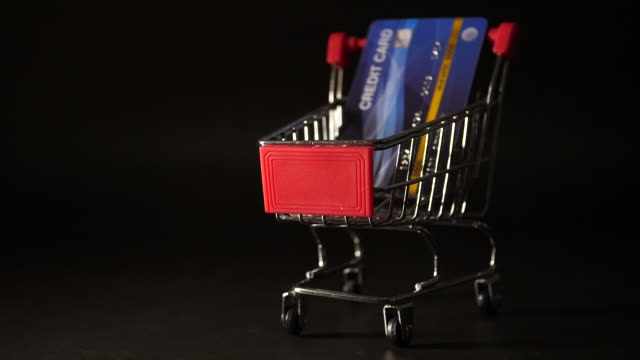 Tarjeta-de-crédito-cayendo-en-mini-carrito-de-compras