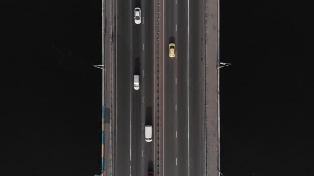 Bridge-highway-dark-water-cars-traffic-aerial-top-view-tracking-shot