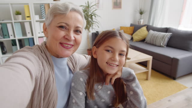 Gealterte-hübsche-Frau-machen-Selfie-mit-Enkelin