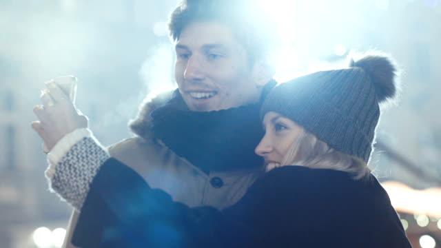 Young-happy-couple-making-winter-selfie-outdoor.