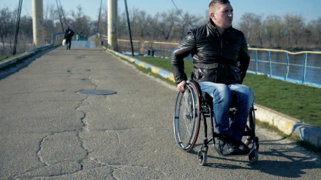 Behinderte-Person-Fahrten-zum-Bahndamm-entlang-Meer-mit-Rollstuhl,-Porträt