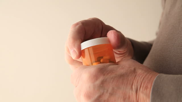 Man-with-tremor-tries-to-open-pills