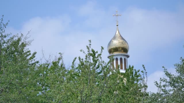 Eastern-orthodox-crosses-on-gold-domes-cupolas-against-blue-cloudy-sky