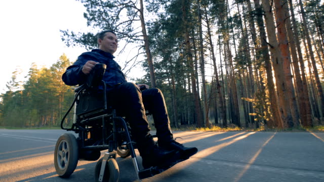Un-hombre-en-silla-de-ruedas-toma-un-paseo-en-un-camino-forestal.