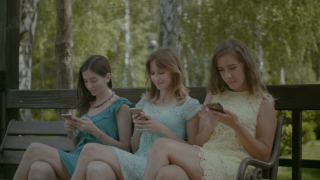 Chicas-lindas-con-teléfono-móvil-en-el-Parque