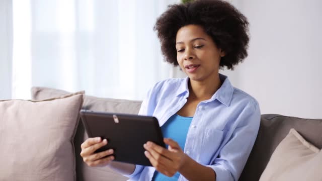 glücklich-Afro-Amerikanerin-mit-Tablet-pc-zu-Hause