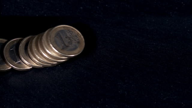 Münzen-von-1-Euro-fallen-vor-schwarzen-Hintergrund,-Slow-Motion