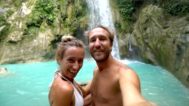 Junges-paar-unter-Selfie-Porträt-mit-einem-wunderschönen-Wasserfall
