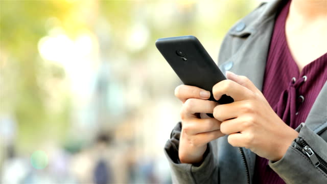 Frau-Hand-SMS-auf-einem-Smartphone-auf-der-Straße