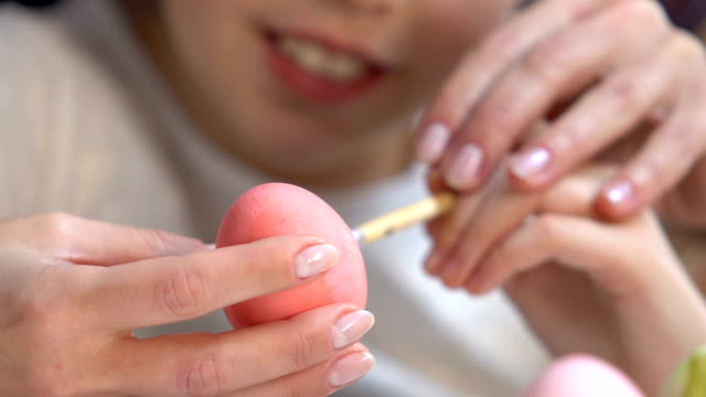 Profesor-ayudando-a-patrones-de-pintura-de-niña-en-huevo-de-Pascua,-preparaciones