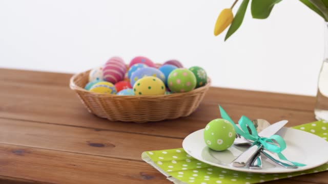 huevos-de-Pascua-en-canasta-y-flores-en-mesa-servida