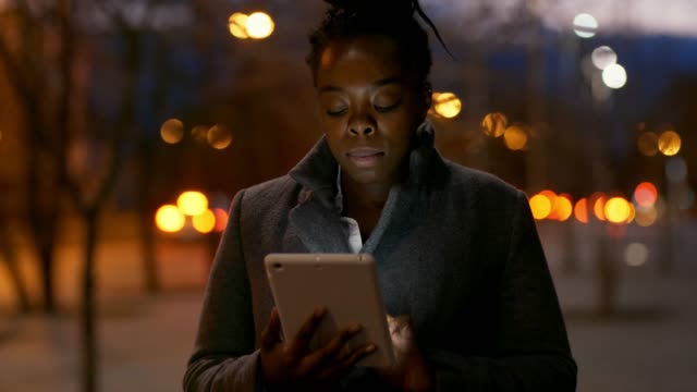 Mujer-africana-con-la-tableta-en-la-noche