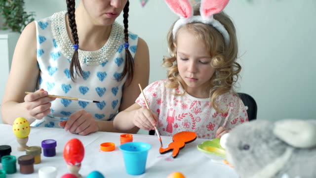 Mother-Helping-her-Daughter-to-Color-Wooden-Bunny