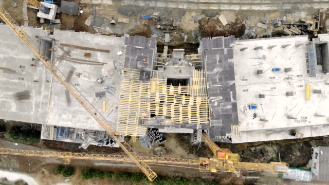 Construction-of-a-high-rise-building,-a-view-from-the-top-with-a-drone.-Workers-build-a-house.-Panorama-from-the-top-of-the-construction-site