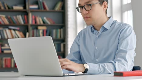 student-preparing-exam-and-learning-lessons-in-school-library,-making-research-on-laptop-and-browse-internet