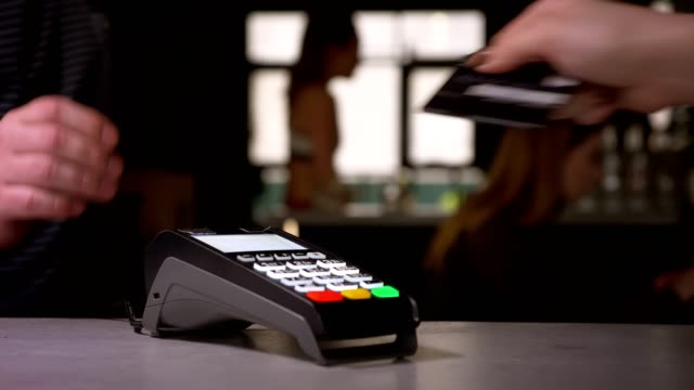 Nahaufnahme-der-Frau-streift-Kreditkarte-durch-Terminal-Maschine-die-Zahlung.