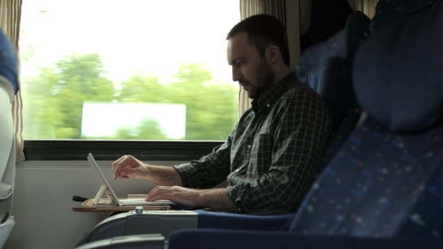 Hübscher-Mann-mit-digitalem-Tablet-während-der-Fahrt-im-Zug