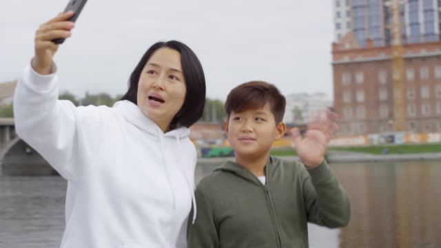 Sportliche-asiatische-Mutter-und-Sohn-Aufnahme-Video-für-Vlog-mit-Smartphone