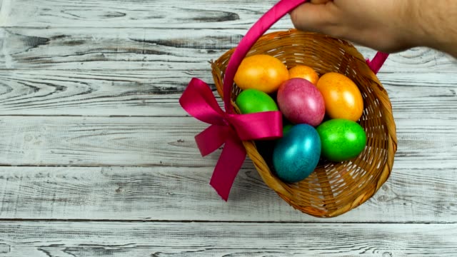Hand-legt-den-Osterkorb-mit-gefärbten-und-bemalten-Eiern-auf-den-Tisch,-Konzept-des-christlichen-Festes-Auferstehungssonntag-oder-Pascha