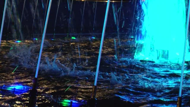 Blue-colored-fountain-jets,-spray-and-blue-lights