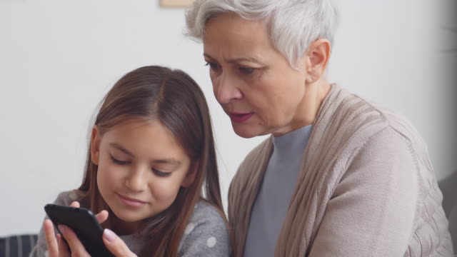 Kind-hilft-Großmutter-Mastering-Smartphone