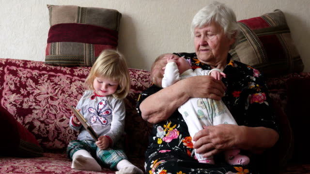 Grandmother-is-rocking-little-baby-on-her-arms