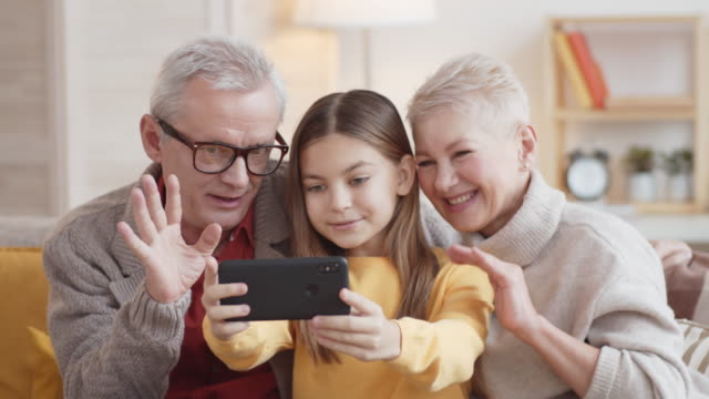 Kaukasische-Großeltern-und-Enkelin-machen-Selfie-auf-Smartphone