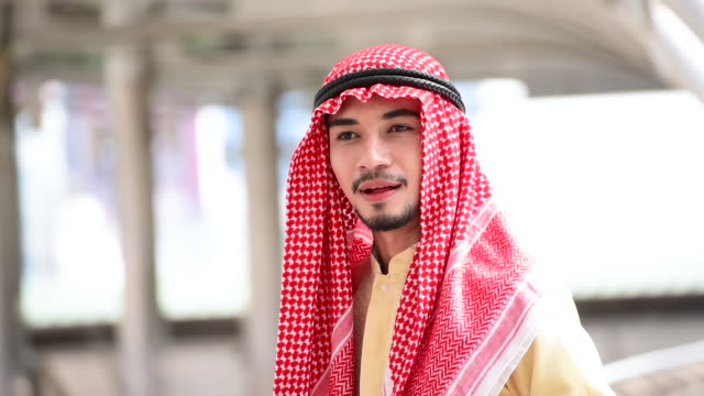 Islamischer-arabischer-Mann-tragen-Hijab-und-muslimische-formale-Kleid-multikulturelle-Vielfalt-Geschäftsleute-lächelnd-Blick-in-die-Kamera-in-modernen-Stadtbild.