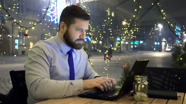 Hombre-de-negocios-escrito-en-ordenador-portátil,-mira-a-cámara,-café,-noche